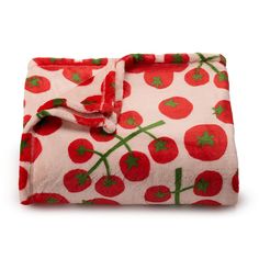 a blanket with cherries on it is folded up and ready to be put into the bed