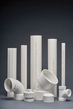 white pipes and fittings are arranged on a gray background