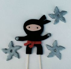 a cake topper made to look like a ninja with stars on the side and in the background