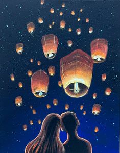 two people looking at lanterns floating in the sky