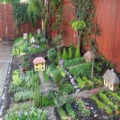 a small garden is shown in front of a fence