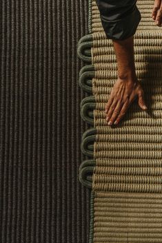 a person's hand on top of a rug