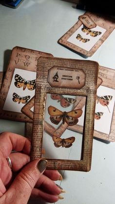 a person holding up some pictures with butterflies on them