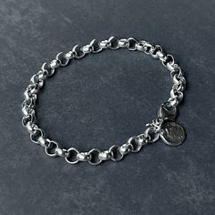 Enhance your style with this elegant sterling silver rolo tag bracelet. Boasting a 6.3mm belcher bracelet and classic design, this bracelet is minimal yet bold. Perfectly paired with a reticulated round tag, this bracelet will add a touch of sophistication to any look. Details: Chain: Sterling Silver Rolo Chain, 6.3mm Clasp: Sterling Silver Lobster claw clasp Sizes: 6" to 9” Full and half sizes Shipping: Ready to ship within one business day Complimentary shipping in the USA Complimentary gift w Sterling Silver Charm Bracelet With Rolo Chain For Gift, Elegant Sterling Silver Rolo Chain Bracelet, Silver Rolo Chain Bracelet, Sterling Silver Rolo Chain Bracelet, Sterling Silver Rolo Chain Bracelet, Gift, Oval Link, Chunky Bracelet, Coin Bracelet, Round Tags, Organic Design