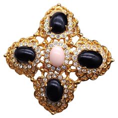 Elevate your ensemble with the Kenneth Jay Lane cabochon cross pin, a stunning accessory that exudes elegance and sophistication. This exquisite piece features a light pink centerpiece cabochon, gracefully encircled by four lustrous black cabochons. Each stone is meticulously prong-set, ensuring security and brilliance, and accented with sparkling clear crystals. The pin is crafted with an ornate layered metal setting in a rich gold tone, providing a luxurious finish that’s sure to turn heads. Whether adorning a scarf, lapel, or handbag, this Kenneth Jay Lane creation is a versatile statement piece that’s perfect for any occasion! Marks: Kenneth Lane Pink Centerpieces, Antique Brooches, Van Cleef Arpels, Kenneth Jay Lane, Gold Finish, Clear Crystal, Jay, Vintage Brooches, Prong Setting