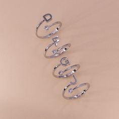 Mix and match our adjustable monogram cuff ring with other rings in your collection or wear it alone. One end of the ring ends with the monogram, while the other ends in a single cubic zirconia stone that adds sparkle. Adjust for a comfortable fit. Adjustable Size: (FITS SIZE 5, 6, 7, OR 8) Stone: Cubic Zirconia Material: Brass Letter Size: 6x6 mm Ring Thickness: 1.5 mm Silver Initial Ring, Monogrammed Cuff, Gold Initial Ring, Personalised Gifts For Friends, Name Ring, Gold G, Letter Ring, Name Rings, Birthday Ring