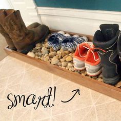 several pairs of shoes are lined up in a planter with rocks and pebbles underneath