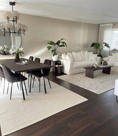 a living room filled with furniture and a dining table in front of a large window