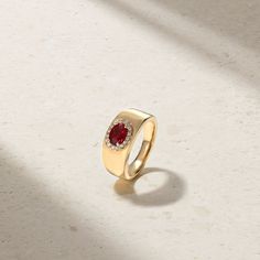 A gorgeous bright red ruby is traced by a halo of twinkling petite diamonds as it rests securely within four prongs. The unique east west orientation of the center stone gives the ring contemporary flair that is matched with a traditional cigar band design offering a fashionable yet heirloom design. The interior of the wide gold band has been sculpted in a rounded profile for maximum comfort that allows for every day wear. Wear yours solo or stack it alongside daintier bands. Metal: 18kt Gold Ru Luxury Ruby Ring With Diamond Halo, Luxury Ruby Diamond Ring With Halo, Luxury Ruby Halo Diamond Ring, Luxury Lab-created Ruby Ring With Halo Setting, Red Oval Diamond Halo Ring, Luxury Red Gemstone Halo Ring, Modern Ruby Diamond Ring, Red Diamond Halo Ring With Oval Shape, Oval Red Diamond Halo Ring