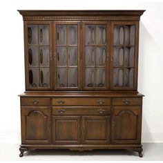 an antique china cabinet with glass doors and drawers