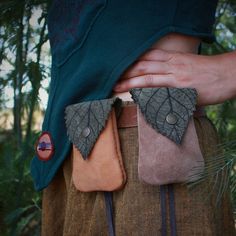 a close up of a person's hands holding onto two different colored leather pieces