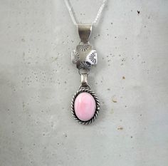 Handcrafted Sterling Silver Queen Conch Jewelry. This elegant necklace has been handmade using 925 Sterling Silver that has been stamped and oxidized. The setting is an oval 16mm x 12mm Pink Conch Cabochon that is in a Bezel setting accented with coiled wire. The pendant is approximately 2 1/2" H x .5" wide and it comes on a 18" 925 Sterling Silver Chain with Lobster Clasp.  Introducing our beautiful Pink Conch Sterling Silver Necklace! This stunning piece is perfect for all the beach-loving fashionistas out there. The Pink Conch pendant is expertly crafted and showcases the beauty of the ocean. Made with high-quality sterling silver, this necklace is not only stylish but also durable for everyday wear. Whether you're heading to a tropical getaway or simply want to add a touch of seaside c Artisan Oval Necklaces, Artisan Oval Engraved Necklace, Artisan Engraved Oval Necklace, Handmade Oval Necklace, Pink Sterling Silver Oval Pendant Jewelry, Pink Sterling Silver Jewelry With Oval Pendant, Hand Forged Oval Link Necklace For Gift, Hand Forged Oval Link Necklace As Gift, Handmade Pink Oval Pendant Jewelry