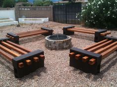 an outdoor fire pit surrounded by wooden benches