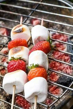 strawberries and marshmallows are being grilled on the grill