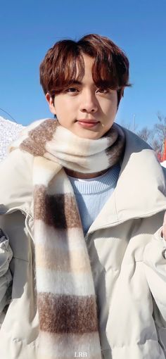 a boy wearing a scarf and jacket in the snow