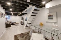 a living room with a glass table and stairs