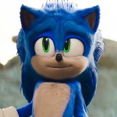 a close up of a blue sonic the hedgehog with green eyes and an angry look on his face