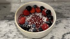 a bowl filled with berries and powdered sugar