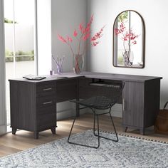 a desk with a mirror, chair and vase on it