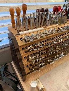 there are many different tools on this wooden holder that is holding knives and spoons