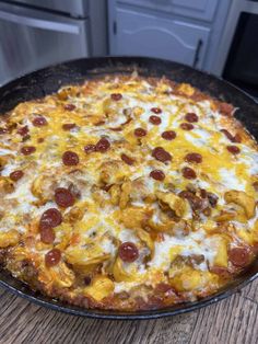 a pizza sitting on top of a pan covered in cheese and pepperoni toppings