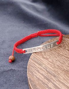 "Handmade red Buddhist woven thread bracelet. The S925 silver charm is inscribed with the Buddhist six true words mantra: Om Mani Padme Hum. These Six True Words 'Om Mani Padme Hum' - are the most common mantra in Tibet. This mantra produces the sound and vibration which allows you to feel at one with the universe. The mantra is considered to have high spiritual and creative power. Six True Words Meaning: Om means the vibration of the universe, symbolizes one's impure body, speech, and mind. Ma Spiritual Sterling Silver Braided Bracelet Gift, Handmade Sterling Silver Braided Friendship Bracelets, Traditional Sterling Silver Braided Bracelet As Gift, Traditional Silver Jewelry For Friendship, Handmade Adjustable Red Sterling Silver Bracelet, Silver Sterling Silver Braided Bracelets For Friendship, Handmade Silver Bracelets For Blessing, Personalized Spiritual Red Bracelets, Red Personalized Spiritual Bracelets