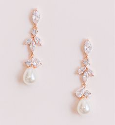 Luminous pearl drop wedding earrings designed with cascading crystals and a teardrop pearl. Cubic zirconia crystals Available in rose gold and silver Length: 1.5" FAQ: How long does it take for my order to be shipped and when will it arrive? It usually takes 2-3 business days for your order to be processed and shipped. Please email us directly or by using the contact form if you need your order rushed. Priority shipping does not rush processing and shipping times, only the time it takes for your Beach Wedding Earrings Brides, Rose Gold Cubic Zirconia Dangle Pearl Earrings, Rose Gold Bridal Drop Earrings With Pearl, Rose Gold Drop Earrings With Pearl Detail For Bridal, Rose Gold Teardrop Pearl Earrings For Wedding, Bride Earrings Gold, Wedding Earrings Bride, Beach Wedding Earrings, Wedding Earrings Silver