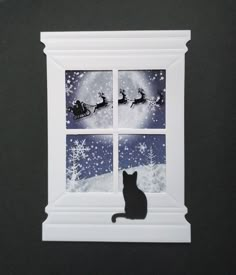 a black cat sitting in front of a window with santa's sleigh