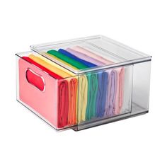 a clear plastic box filled with lots of different colored clothes on top of each other