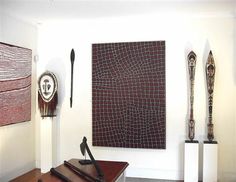 an art gallery with sculptures and artwork on the wall, including two large abstract paintings