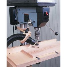 a drilling machine is on top of a piece of wood