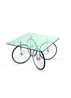 a glass table with two wheels attached to the top and one wheel on each side