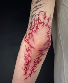 a man's arm with red and black ink on it