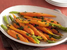 a white plate topped with asparagus and carrots on top of a table