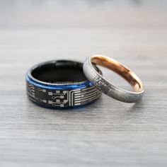 two wedding rings sitting next to each other on a table