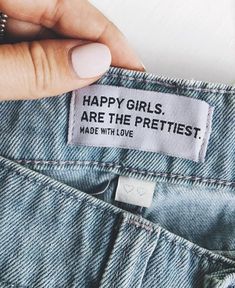 a woman's hand holding up a label that says, happy girls are the prettiest made with love