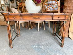 a wooden desk with wicker chairs and rattans around it in a store