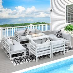 a white patio furniture set sitting on top of a wooden deck next to a swimming pool