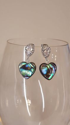 Abalone  hearts with teardrop CZ accented silver ear posts. Approximately 1.5 inches long. Silver Dangle Heart Earrings For Party, Sterling Silver Dangle Heart Earrings For Party, Silver Heart Charm Earrings For Formal Occasions, Silver Heart Charm Earrings For Formal Events, Elegant Silver Teardrop Heart Earrings, Teardrop Earrings With Heart Charm For Anniversary, Teardrop Heart Earrings For Gift, Silver Teardrop Crystal Earrings For Anniversary, Anniversary Teardrop Earrings With Heart Charm