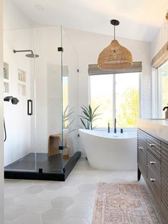 a bathroom with a large bathtub, sink and shower head in it's center