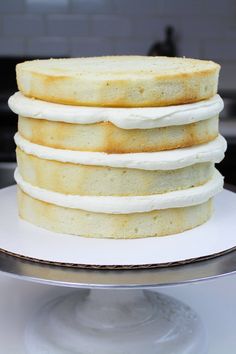 a stack of white cake sitting on top of a metal pan covered in frosting