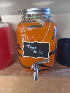 a mason jar filled with tiger juice on top of a wooden shelf