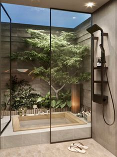 a bathroom with a large glass shower and a tree on the wall next to it