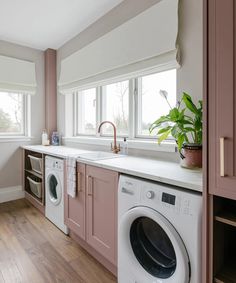 a washer and dryer in a kitchen next to a window with pink cabinets