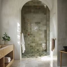 an arched doorway leads to a tiled bathroom