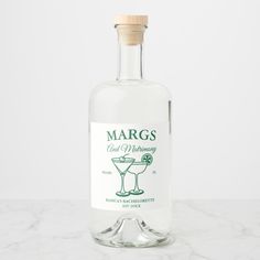 a bottle of margs gin is sitting on a marble countertop with a wooden stopper