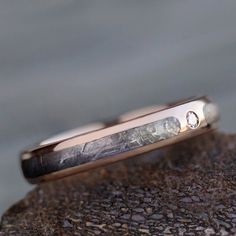 a close up of a wedding ring on top of a rock