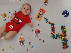 a baby laying on top of a table with candy and candies all around it