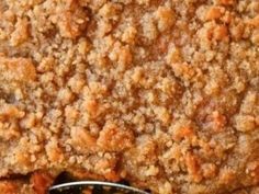 a close up view of a pie with crumbs on it and a spoon in the foreground