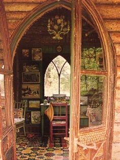 an arched doorway leading into a room with many pictures on the wall